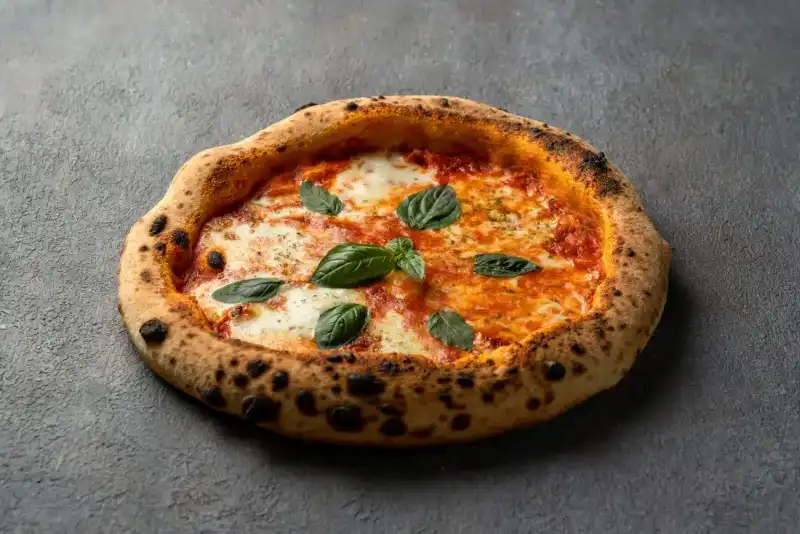 Homemade Margherita pizza baked with fresh tomatoes, mozzarella, and basil at Secret Oven restaurant