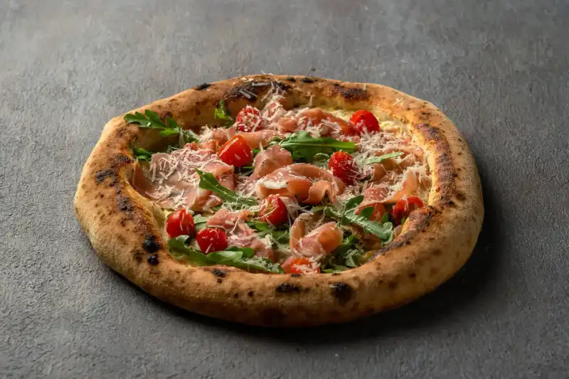 Homemade Pizza Parma with Italian prosciutto, rocket salad, and parmesan at Secret Oven restaurant