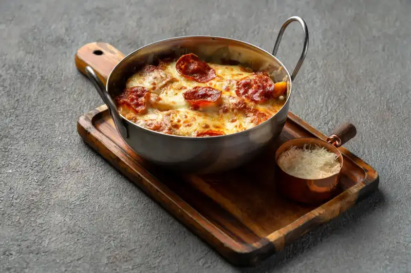 Close-up of cheesy baked penne calabrese pasta fresh from the oven at Secret Oven Koh Samui