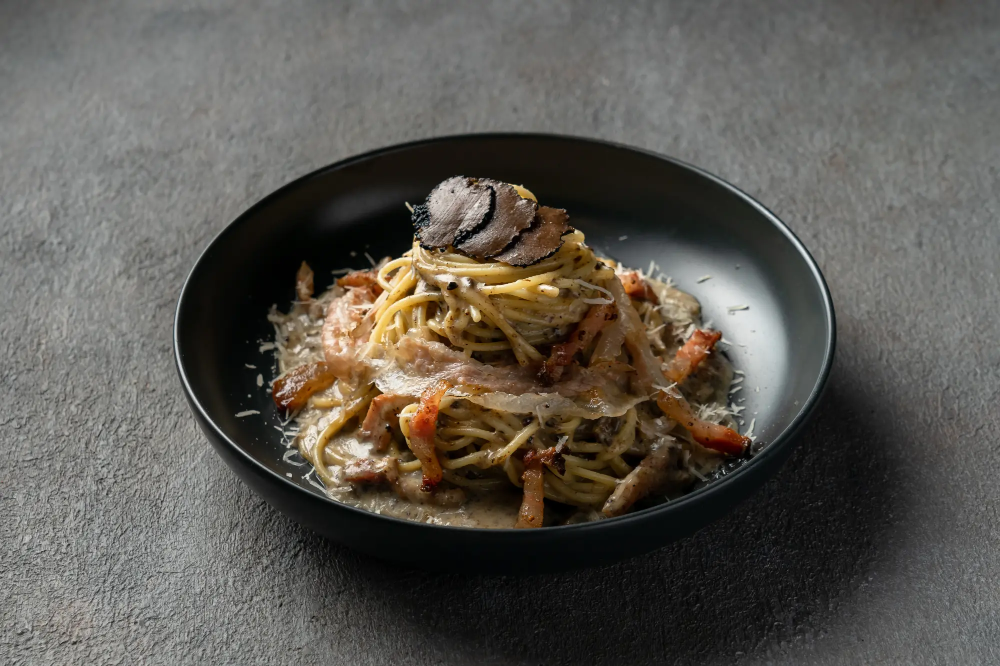 Close-up of creamy carbonara pasta with truffle aroma and pancetta at Secret Oven Koh Samui