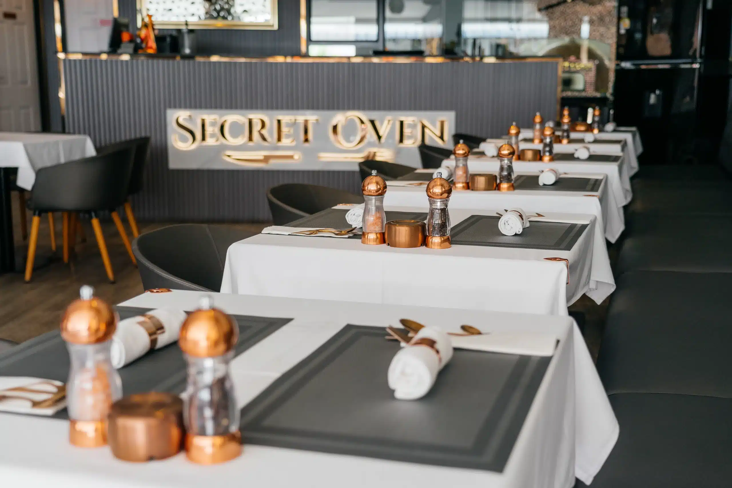 Secret Oven restaurant showcasing warm lighting, handcrafted tables, and welcoming vibes