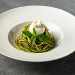 Fresh pasta tossed in basil pesto sauce topped with creamy burrata at Secret Oven Koh Samui
