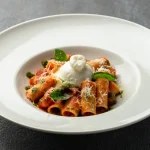 Italian rigatoni pasta with basil tomato sauce topped with creamy burrata at Secret Oven Koh Samui